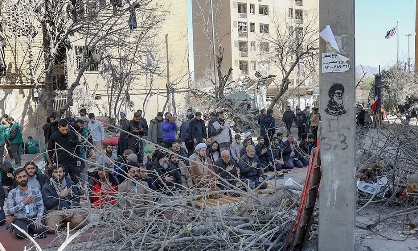Modliaci sa ľudia pri troskách po bombardovaní